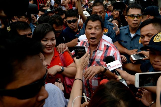 Presidential frontrunner Rodrigo Duterte leaves the voting precint after casting his ballo