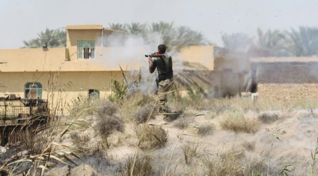 A member of the Iraqi pro-government forces fires a rocket-propelled grenade launcher duri
