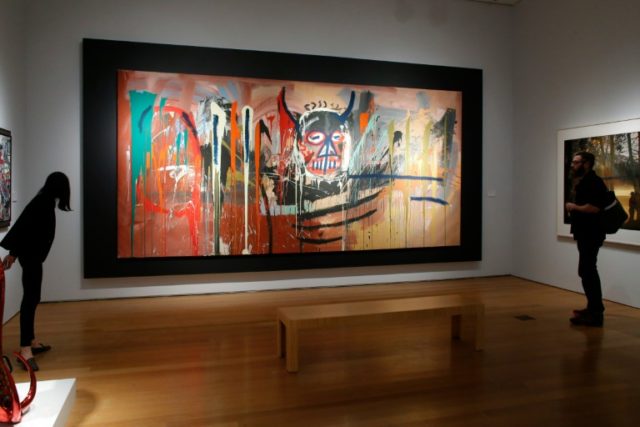 People observe 'Untitled' by artist Jean-Michel Basquiat at Christie's auction house in Ne