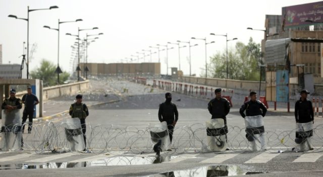 Riot police stand guard at the Jumhuriyah Bridge, a route leading from Tahrir Square to th
