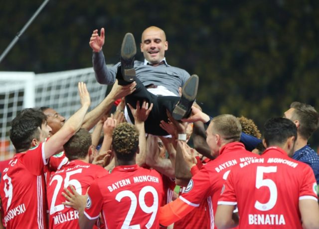 Bayern Munich's out-going coach Pep Guardiola is thrown in the air by his players after th