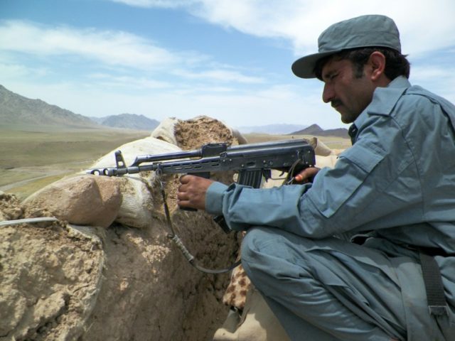 An Afghan policeman keeps watch at a police checkpoint on the Kandahar-Tarin Kot highway