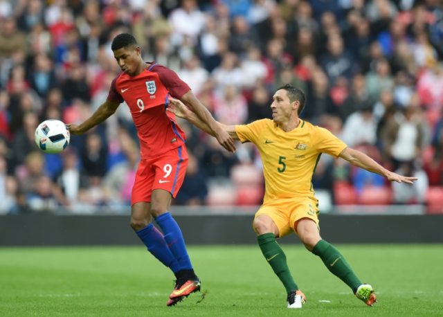 England's Marcus Rashford (L) fights off a challenge from Australia's Mark Milligan during