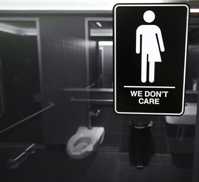 Gender neutral signs are posted in public restrooms on May 10, 2016 in Durham, North Carol