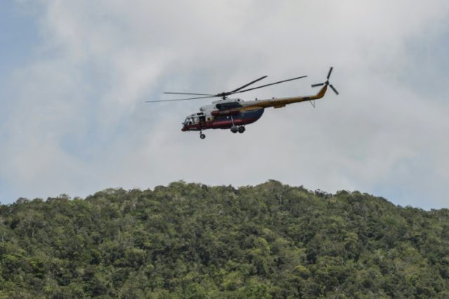 A Malaysian search and rescue helicopter flies near the Malaysia-Thailand border in Wang K