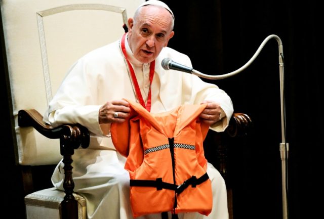 Pope Francis shows the life jacket of a young victim drowned in the Mediterranean sea tryi