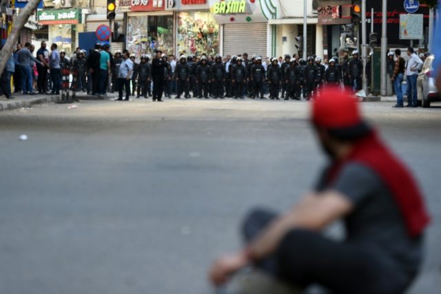 A protester sits in front of riot policemen during a demonstration on April 15, 2016 in ce