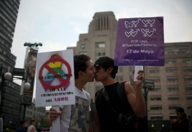 Activists kiss during an event for International Day against homophobia, in Mexico City on