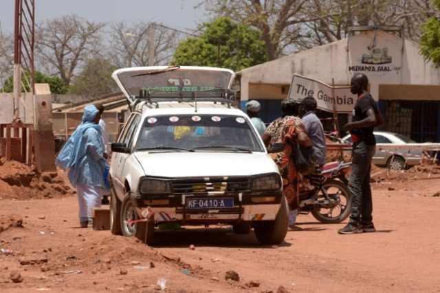 Travelers stop along the Senegalese-Gambia border in the town of Keur Ayip