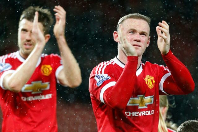 Manchester United's midfielder Michael Carrick (L) and striker Wayne Rooney applaud the fa