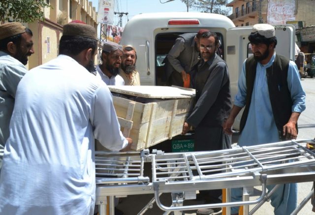 Pakistani security officials and hospital staff move a dead body into a morgue in Quetta o
