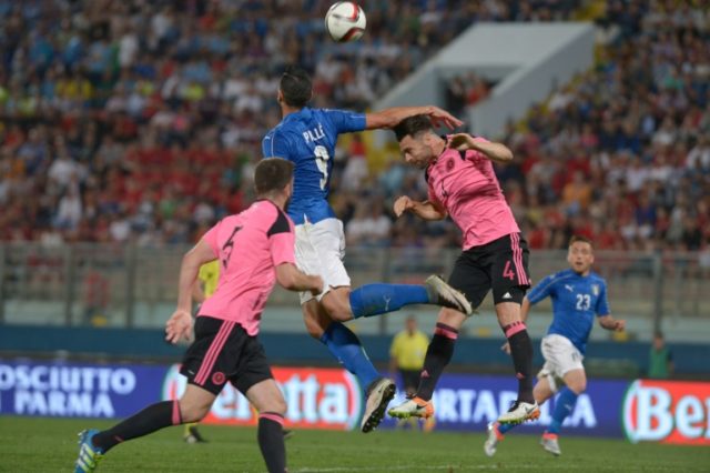 Italy's Graziano Pelle (C) fights for the ball with Scotland's Russell Martin (R) at the N