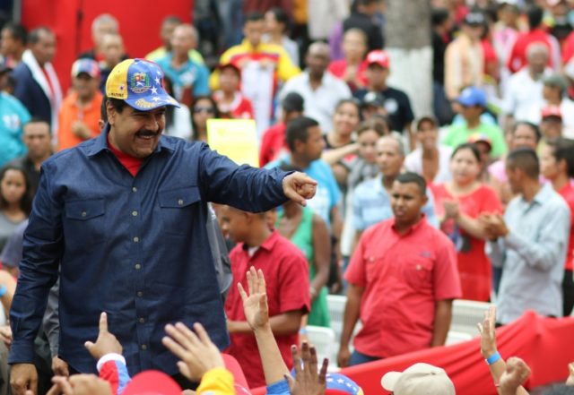 Venezuelan President Nicolas Maduro (L) greets supporters during a rally at the Miraflores