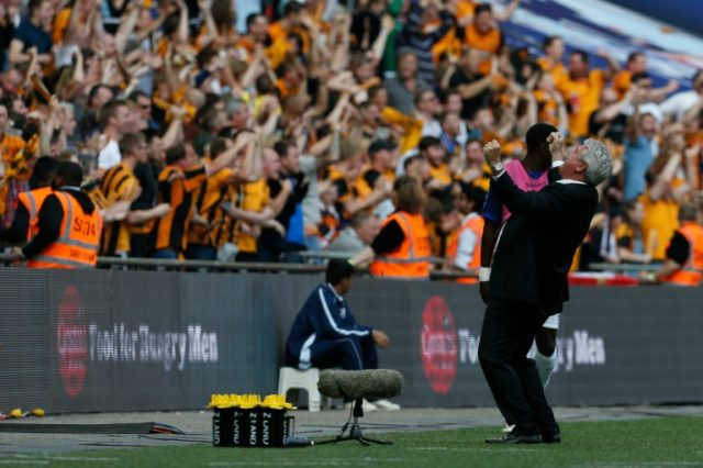 Hull City's manager Steve Bruce (R) celebrates with the fans on the touchline after the op