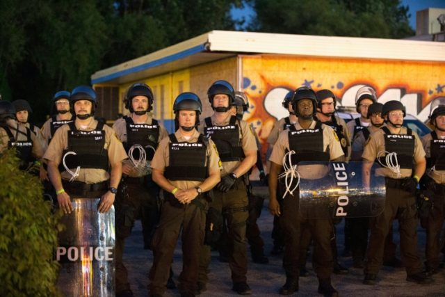Police stand guard on the anniversary of the shooting of Michael Brown in August 2015 in F