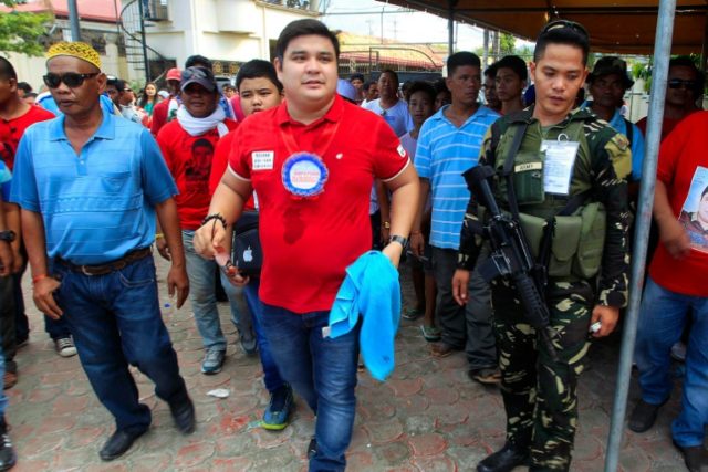 Shariff Aguak's mayoral candidate Sajid Ampatuan is escorted by supporters and bodyguards