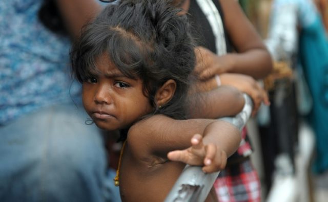 A young Sri Lankan flood victim looks on at a roadside camp in Kelaniya, on the outskirts