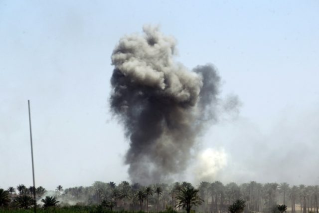 Smoke billows in the background as Iraqi government forces advance near al-Sejar village,