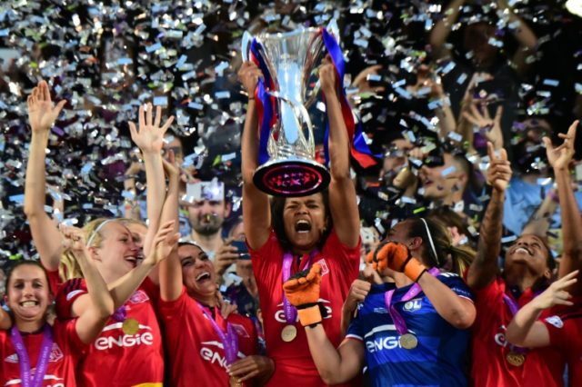 Olympique Lyonnais' captain Wendie Renard holds the trophy to celebrate with teammates aft
