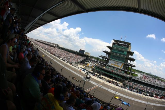 Cars race on the front stretch during the 100th running of the Indianapolis 500 on May 29,