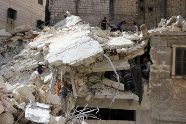 Syrian Civil Defence workers inspect a heavily damaged building on May 17, 2016, in the re