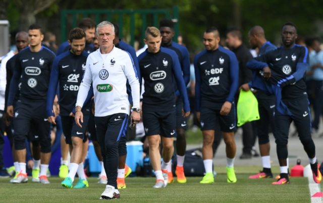 France's head coach Didier Deschamps (C) and his players arrive for a training session for
