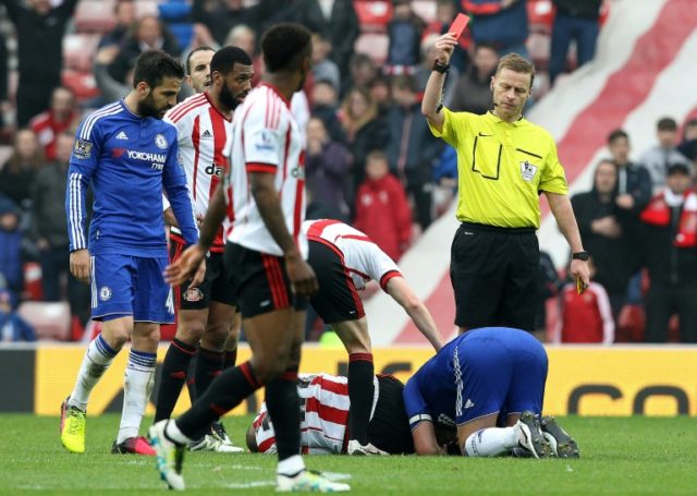 Referee Mike Jones (R) shows a red card to Chelsea's John Terry (R) following his challeng