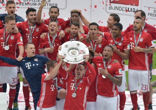Bayern Munich's midfielder Franck Ribery holds the Bundesliga trophy after Bayern Munich w