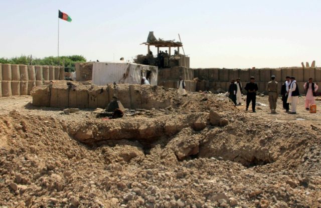 Afghan police inspect the site of a suicide car bombing in the Nad Ali district of Helmand
