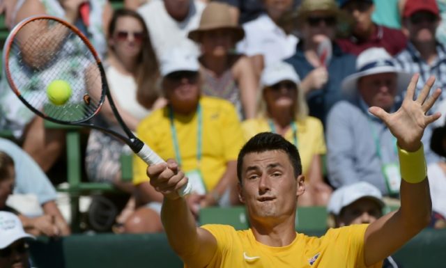 Bernard Tomic of Australia plays a shot during the men's reverse singles match at the Worl