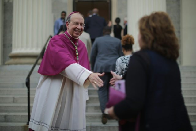 Catholic Archbishop of Baltimore William Lori (L) welcomes people to the Basilica of the N