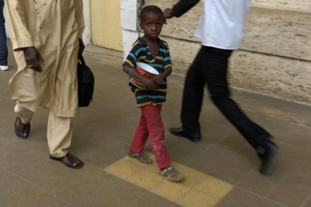 A young Senegalese boy, locally called talibe, begs for ailments in a street in Dakar
