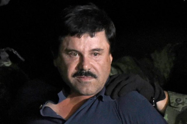 Drug kingpin Joaquin "El Chapo" Guzman is escorted into a helicopter at Mexico City's airp