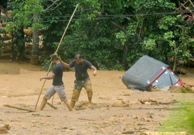 Sri Lankan soldiers engage in relief and rescue efforts following a landslide in the villa