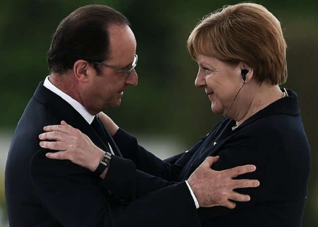 French President Francois Hollande (L) embraces German Chancellor Angela Merkel during a r