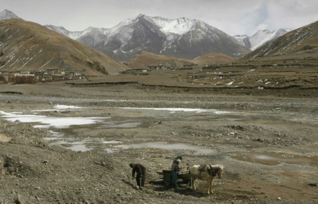 Tibetan's collect rocks in the Nyang-Chu valley surrounded by the high peaks of the Himala