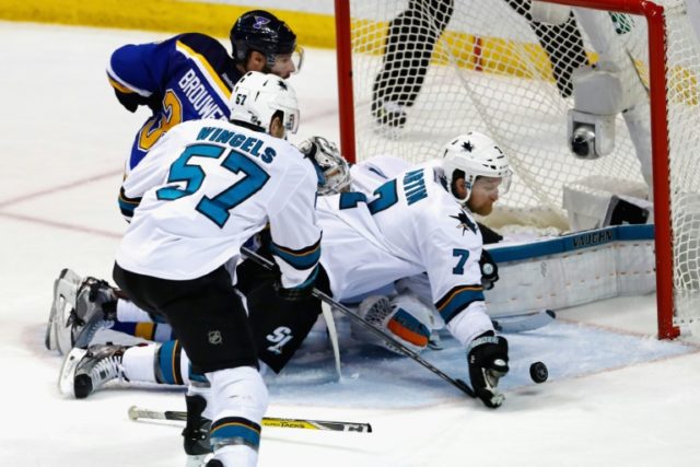 Paul Martin of the San Jose Sharks knocks the puck away from the goal against the St. Loui