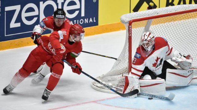 Belarus' forward Artur Gavrus (C) attacks Canada's goalie Cam Talbot (R) on May 9, 2016
