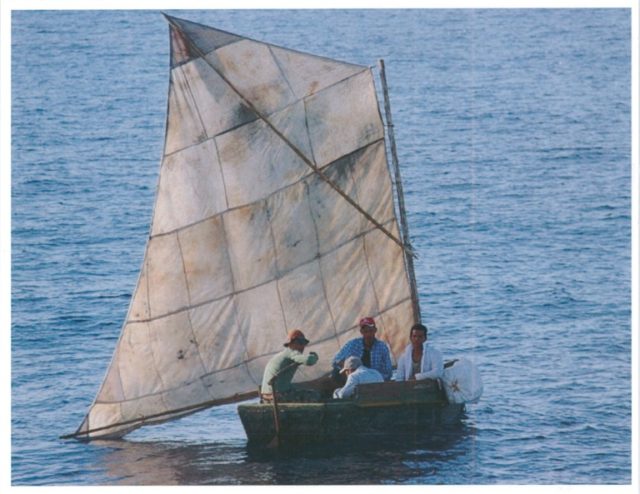 Four Cuban migrants sit in their rustic sailing vessel prior to being interdicted by the C