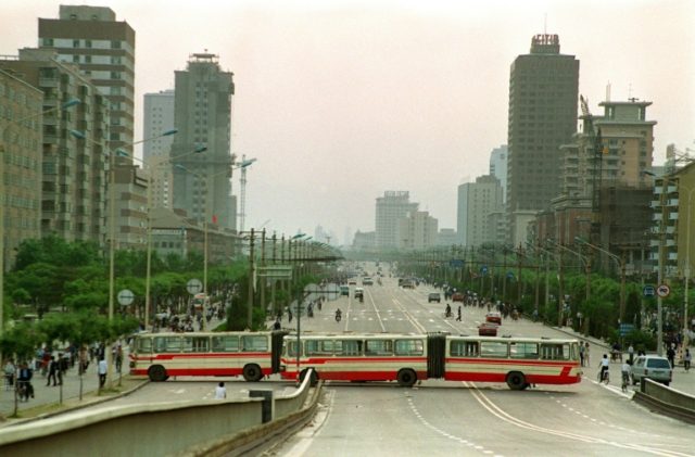 Two city buses block Jianguomen Avenue, the main street to Tiananmen Square, on May 21, 19