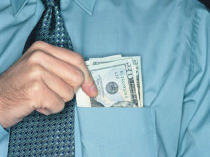 Businessman holding twenty dollar notes in shirt pocket, close-up