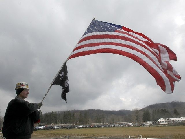 Dave Thearle, a member of the United Mine Workers of America, waves an American Flag durin