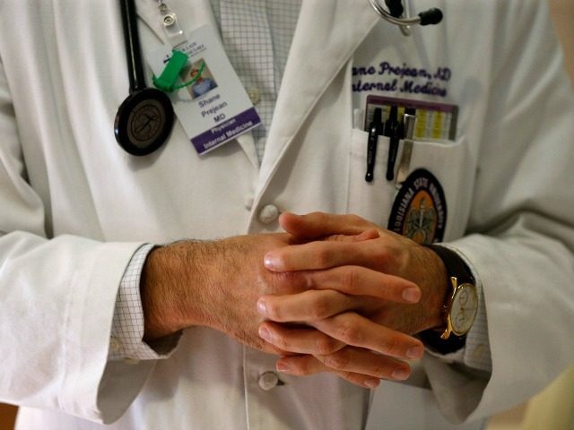 In a Friday, May 6, 2016 photo, Dr. Shane Prejean briefs a group of medical residents and medical students while visiting a patient at Our Lady of the Lake Regional Medical Center in Baton Rouge, La. Louisiana’s deep, persistent budget troubles are endangering the future of medical training programs. Proposed …