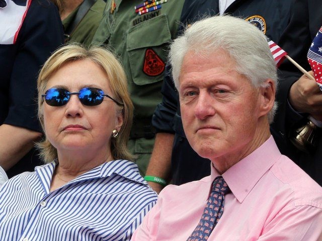 Democratic presidential candidate Hillary Clinton sits with her husband former President Bill Clinton as they attend a ceremony after walking in a Memorial Day parade Monday, May 30, 2016, in Chappaqua, N.Y. (AP Photo/Mel Evans)