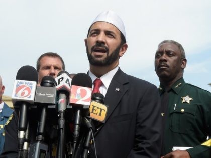 Imam Muhammad Musri, center, president of the Islamic Society of Central Florida, addresse