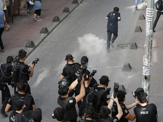 Turkish police officers fire tear gas and rubber bullets to disperse demonstrators who gathered for a gay pride rally despite a government ban, off Istiklal Avenue, central Istanbul's main shopping road, Sunday, June 19, 2016. Istanbul's governor had banned gay, lesbian and transgender individuals from holding two annual parades this …