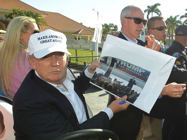 GOP presidential candidate Donald Trump shows a photograph a supporter wants him to sign,