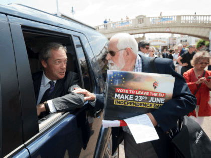 UK Independence Party (UKIP) leader Nigel Farage (L) speaks with a supporter as he leaves