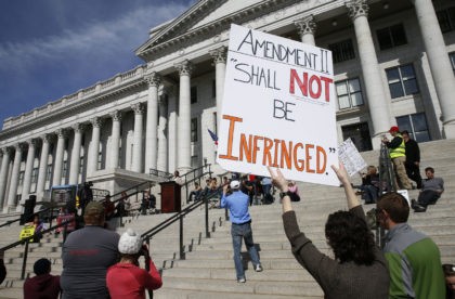 SALT LAKE CITY, UT - MARCH 2: Gun rights supporters hold signs and listen to former Republ