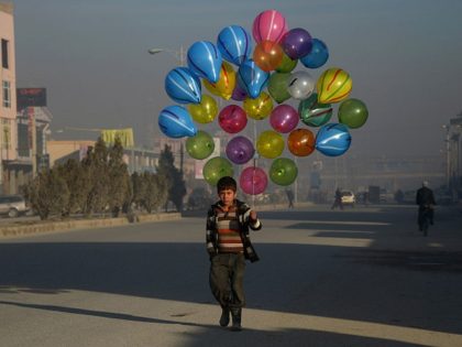 TOPSHOT - Afghan boy Hizbullah, 10, walks as he looks for customers to buy his balloons on